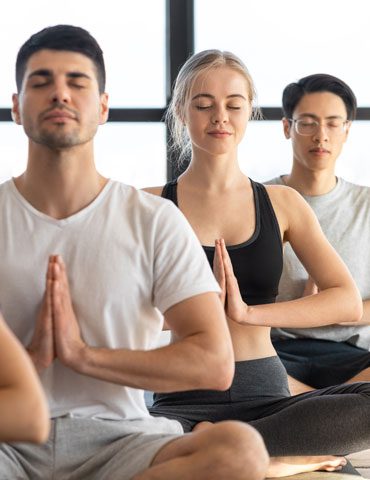 A group of people sitting in the middle of a class.