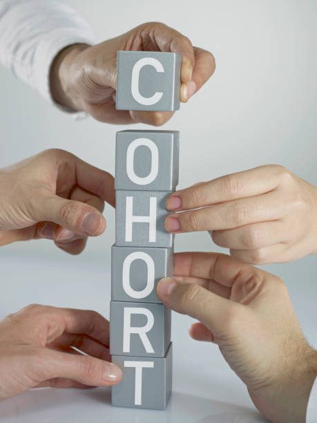 A group of people holding blocks that spell out " cohort ".